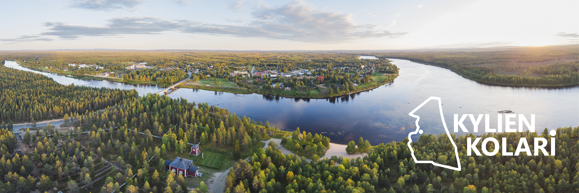 Ilmakuva Kolarin kirkonkylästä: leveä joki kiertyy maiseman halki muodostaen niemimäisen alueen, jolla sijaitsee kylän rakennuksia, teitä ja silta. Ympärillä levittäytyy laaja metsäalue ja hajanaista asutusta. Etualalla metsässä näkyy punaisia rakennuksia ja peltoja. Kuvan oikeassa reunassa on valkoinen Kolarin kartan muotoinen kuvio sekä teksti “Kylien Kolari”.